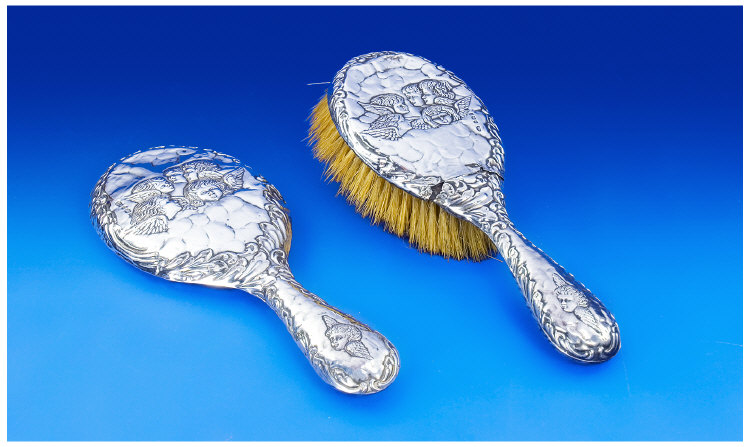 Appraisal: Edwardian Silver Backed Hand Mirror and Brush Embossed with cherubs