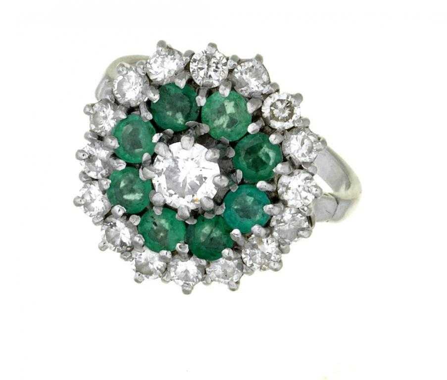 Appraisal: A DIAMOND AND EMERALD CLUSTER RING with larger central round