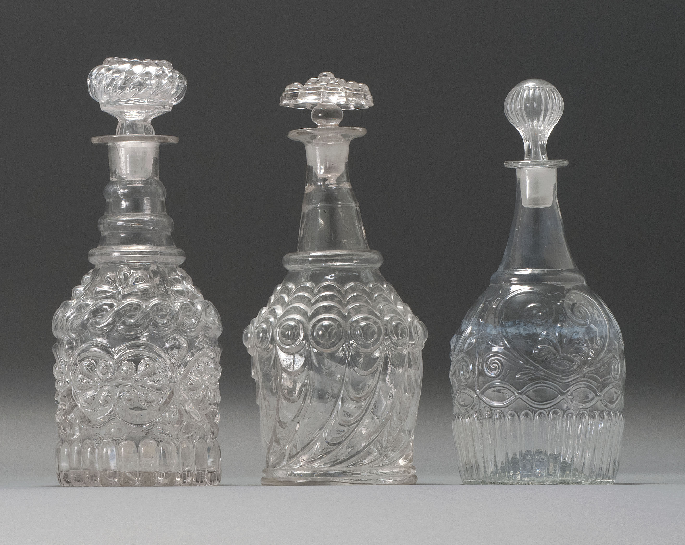 Appraisal: THREE CLEAR GLASS BLOWN -MOLD DECANTERS Second Quarter of the