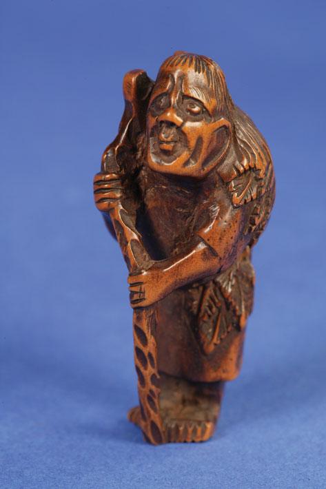 Appraisal: A JAPANESE HARDWOOD NETSUKE of an immortal carrying sacks suspended