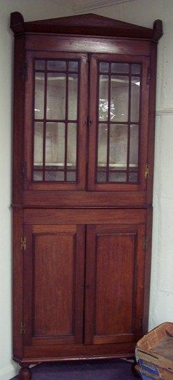 Appraisal: A free standing th Century mahogany corner cupboard the architectural