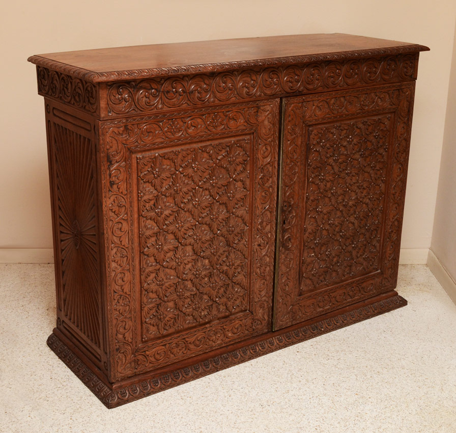 Appraisal: PROFUSELY CARVED SIDE CABINET Carved with foliate and floral motifs