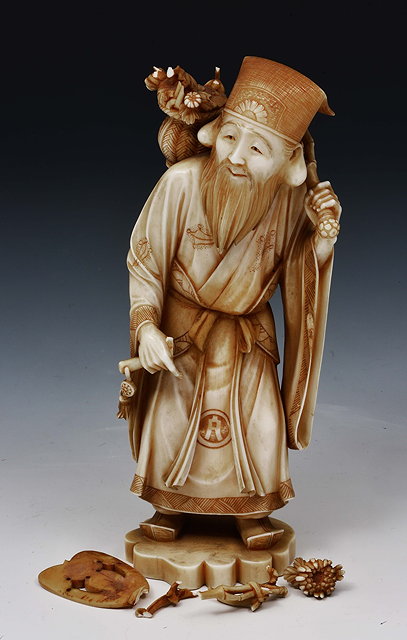 Appraisal: A Japanese ivory okimono of a standing jurojinMeiji periodsigned in