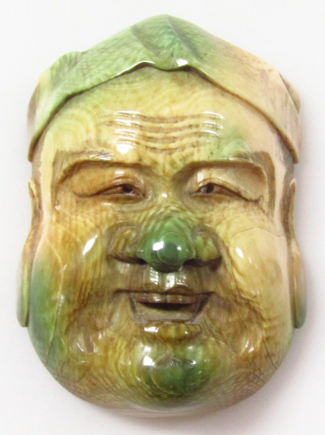 Appraisal: A Chinese heavily polished Buddha head in green and yellow