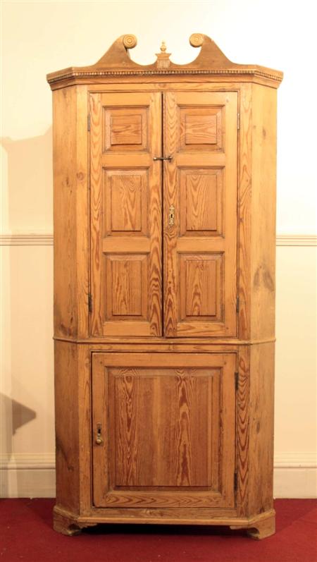 Appraisal: An early th century pine corner cupboard the swan neck