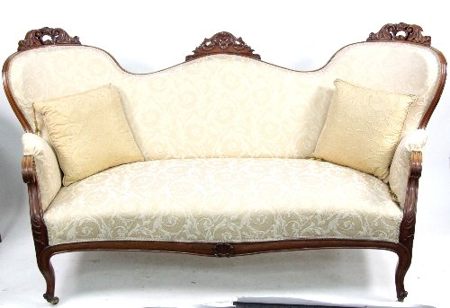 Appraisal: A Victorian walnut settee with scroll carved frame arms and