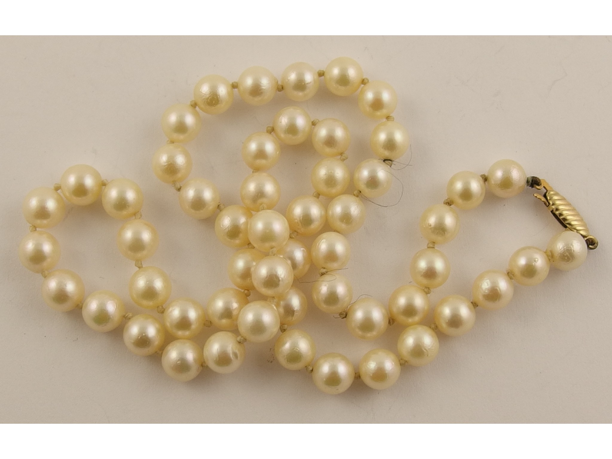 Appraisal: A string of cultured pearls with a yellow metal clasp