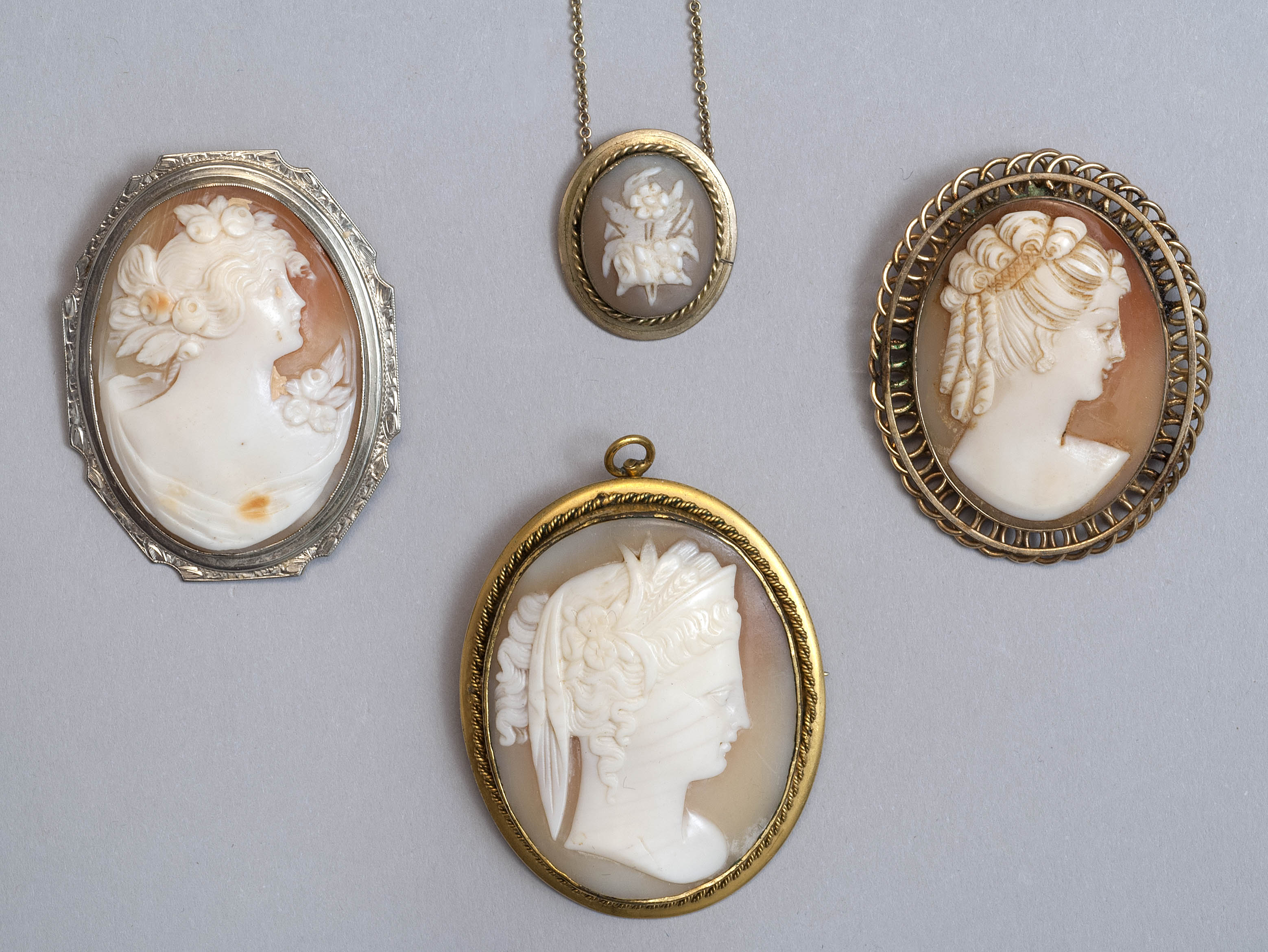 Appraisal: FOUR SHELL CAMEO ITEMS Three brooches and one pendant necklace