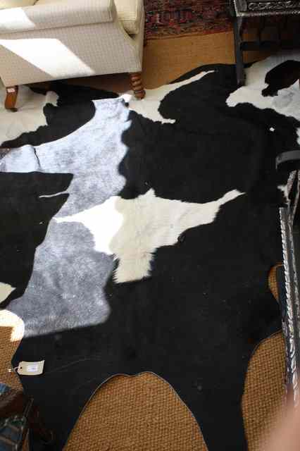 Appraisal: A COW HIDE RUG wide