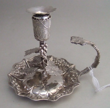 Appraisal: A silver chamber candlestick with foliate decoration to the stem