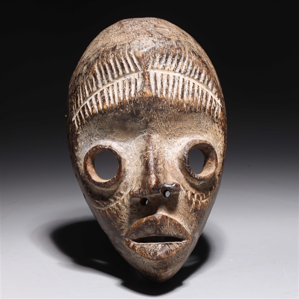 Appraisal: Carved wooden mask in the style of the Dan people