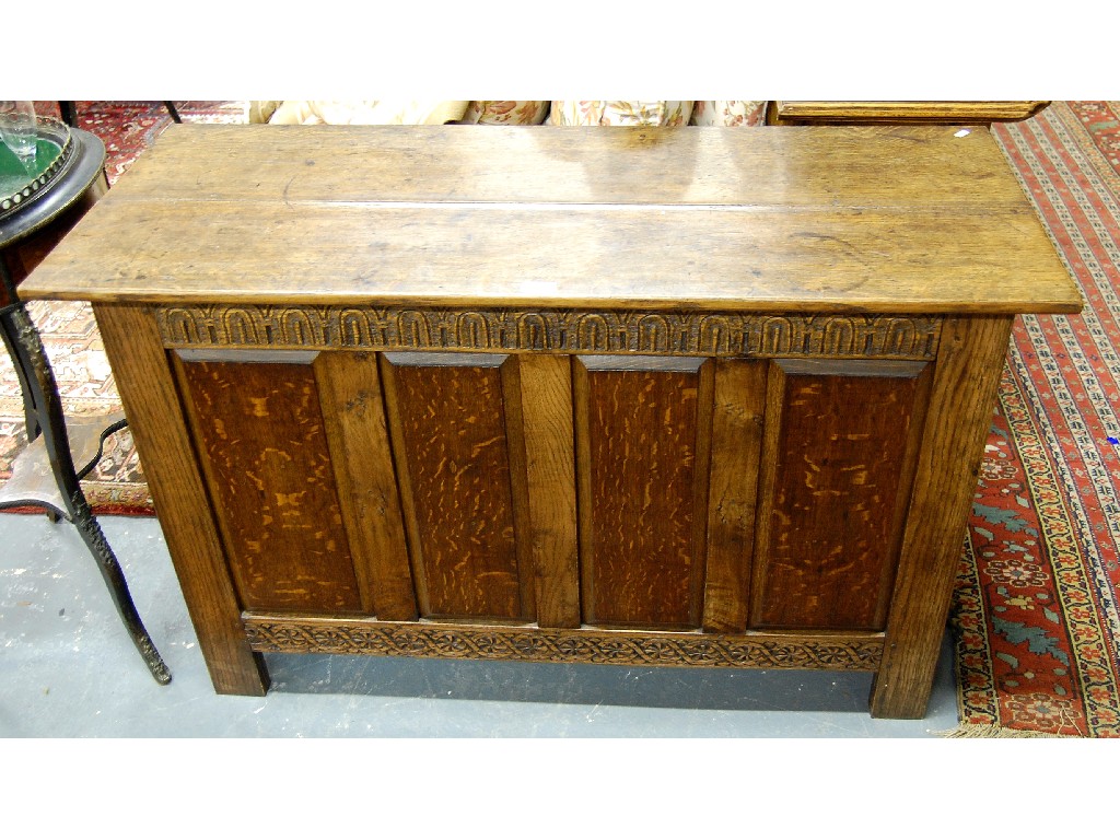 Appraisal: An oak coffer with planked top and panelled sides cm