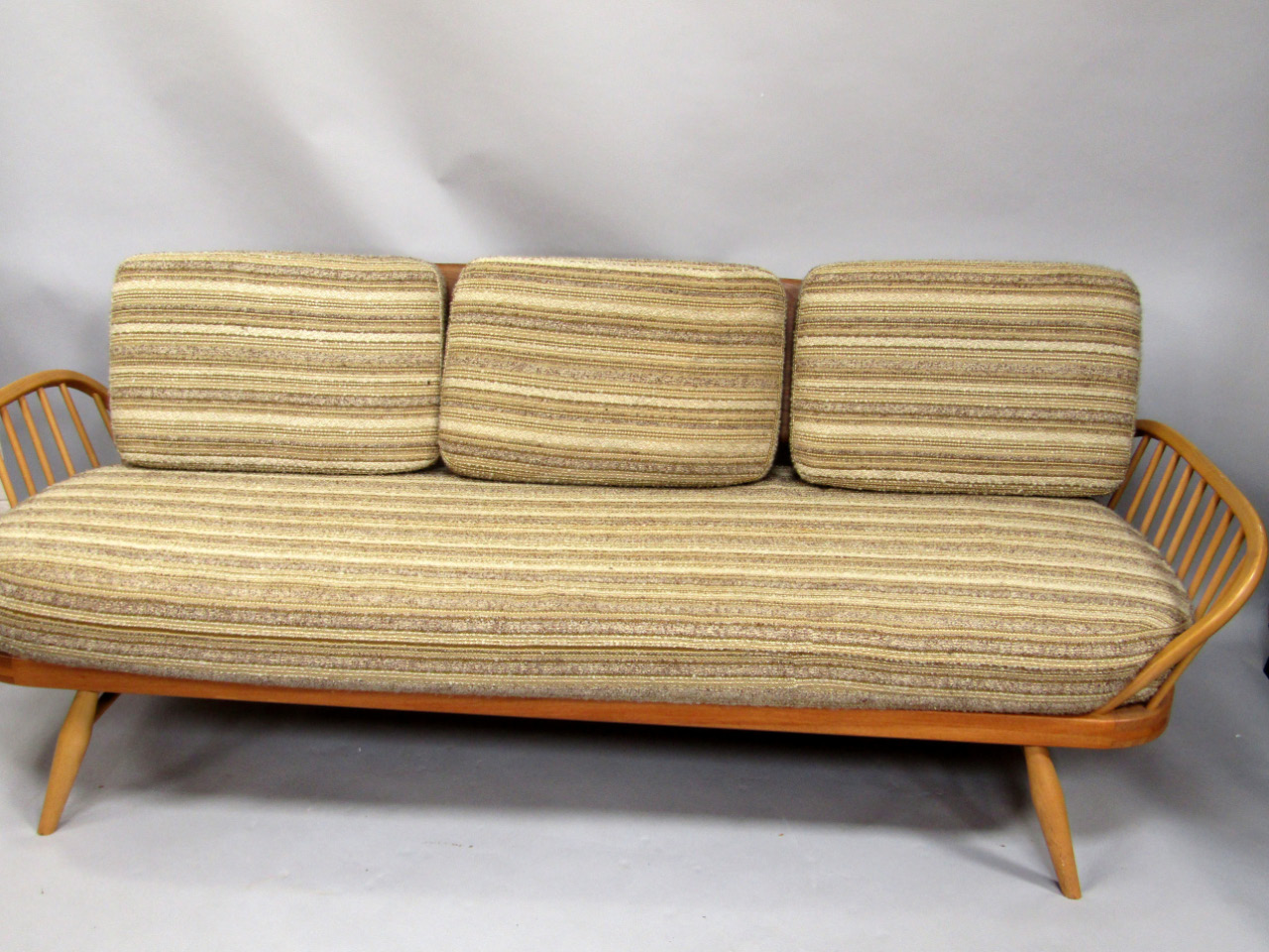 Appraisal: An Ercol light elm retro style sofa with slatted ends