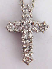 Appraisal: A white metal tests carat gold diamond set cross pendant