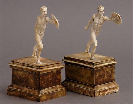 Appraisal: PAIR OF CONTINENTAL CARVED IVORY FIGURES OF NUDE GLADIATORS AFTER