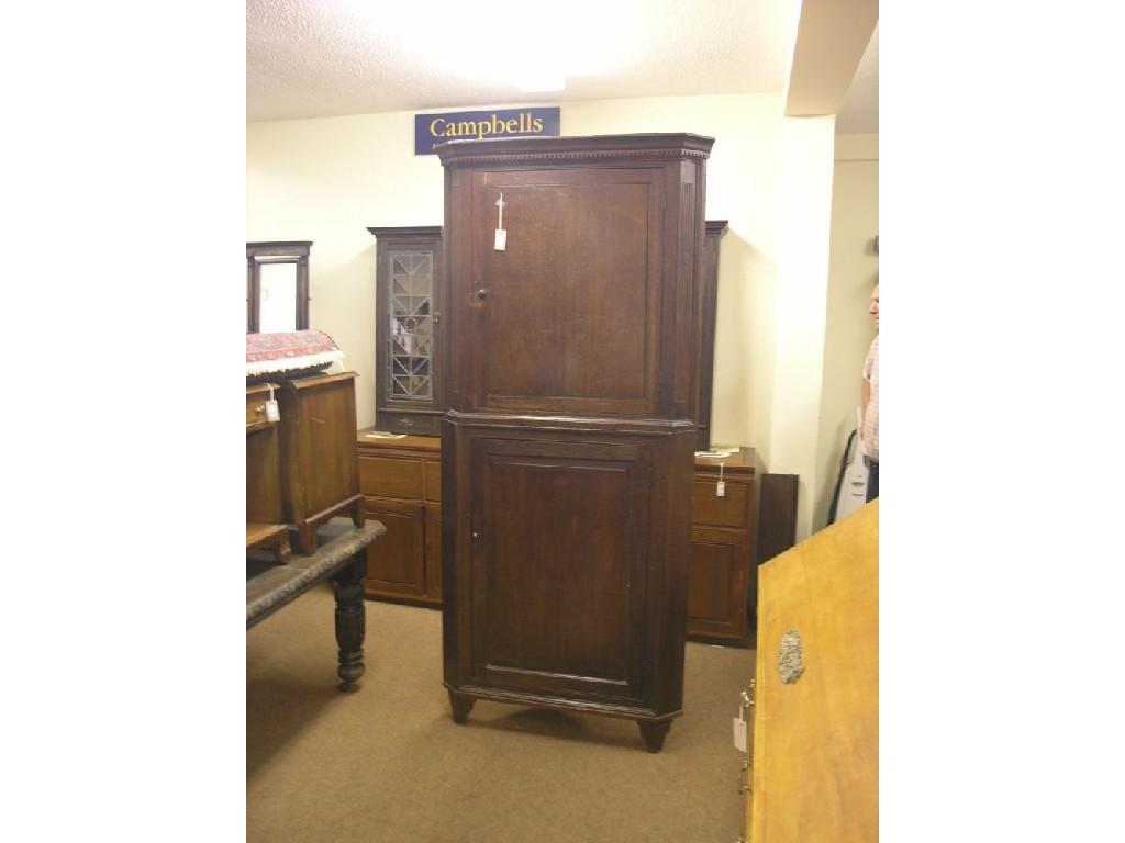 Appraisal: A Georgian oak floor-standing corner cupboard dentil pediment above panelled