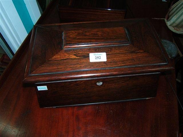 Appraisal: A rosewood tea caddy of sarcophagus form wide