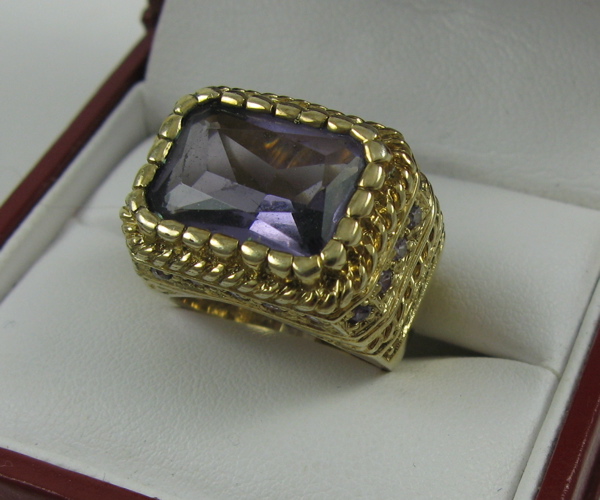 Appraisal: AMETHYST RING centering a large rectangular-cut amethyst with an estimated