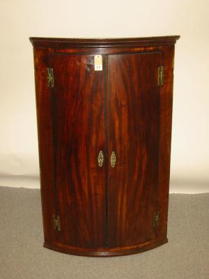 Appraisal: A GEORGE III MAHOGANY CORNER CUPBOARD c of bowed form