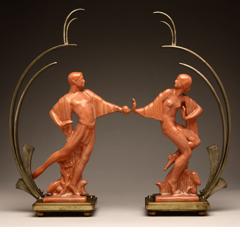 Appraisal: A pair of Art Deco bronze and steel-mounted rose-glazed figures