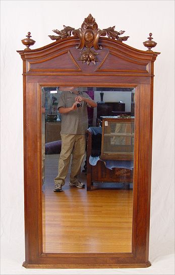 Appraisal: VICTORIAN WALNUT PIER MIRROR Highly carved wood crest Beveled mirror