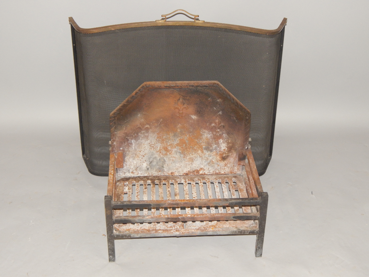 Appraisal: A modern cast iron fire grate with detachable back with