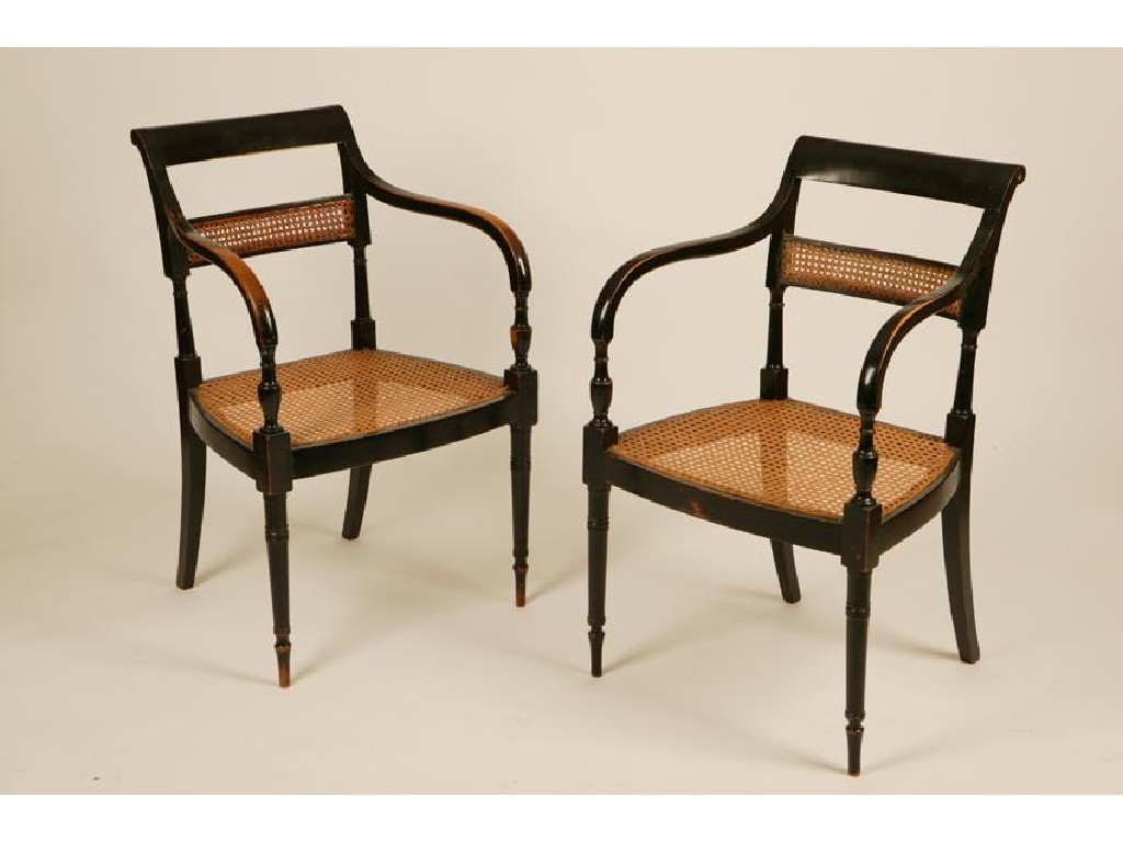 Appraisal: A SET OF FOUR REGENCY EBONISED ELBOW CHAIRS with caned