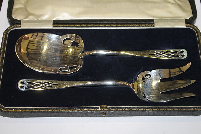 Appraisal: A CASED PAIR OF SILVER PLATED SALAD SERVERS of stylised