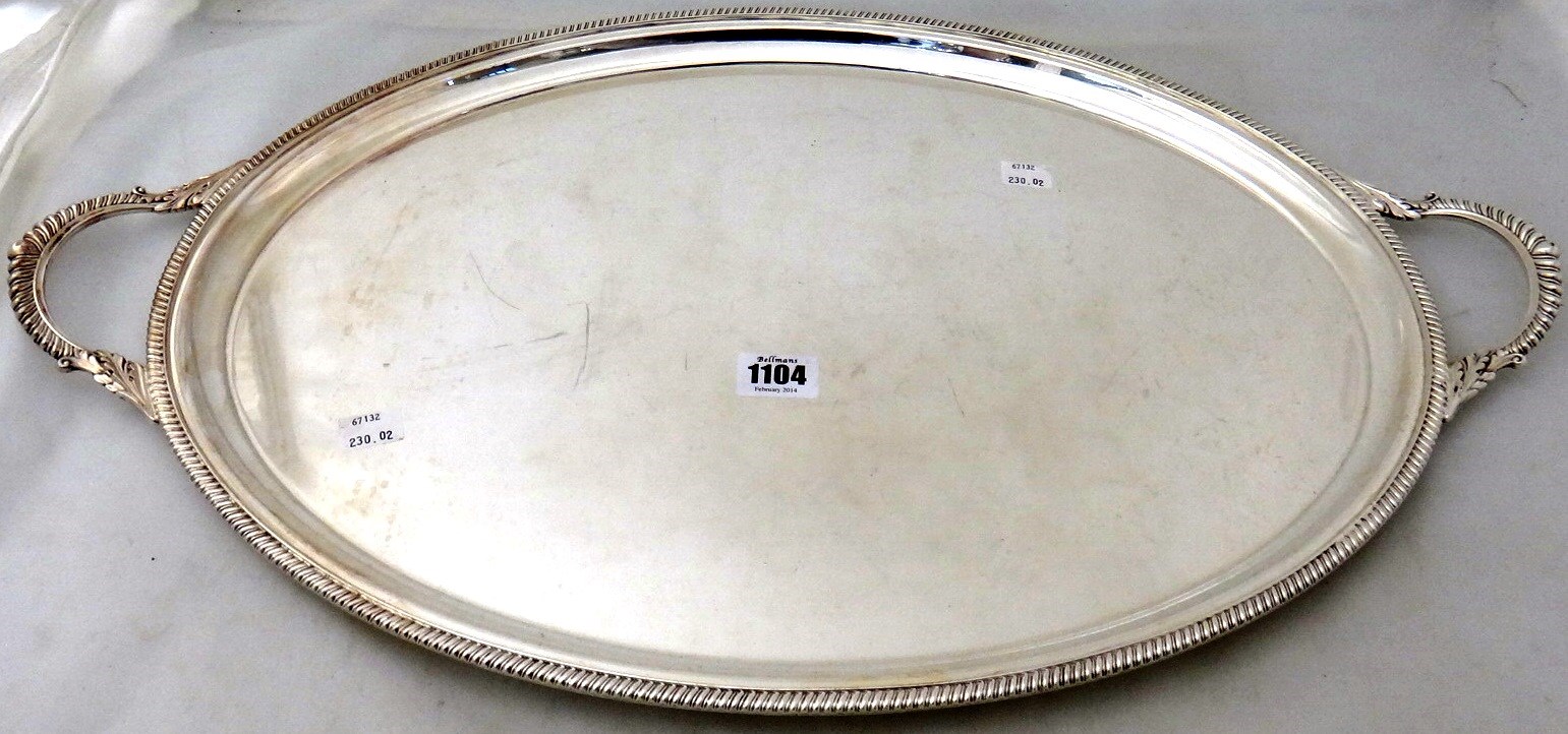 Appraisal: A plated oval twin handled tray decorated with a gadrooned