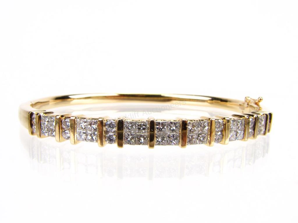 Appraisal: A K yellow gold hinged bangle bracelet with twenty-eight invisible