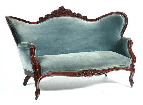 Appraisal: VICTORIAN SOFA Mahogany with a carved crest and dark blue