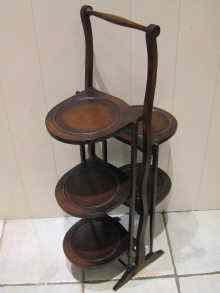 Appraisal: A mahogany folding cake stand with five trays circa