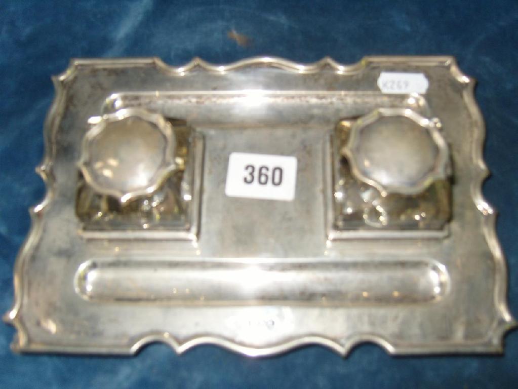 Appraisal: A silver inkstand of shaped form and stylised supports fitted