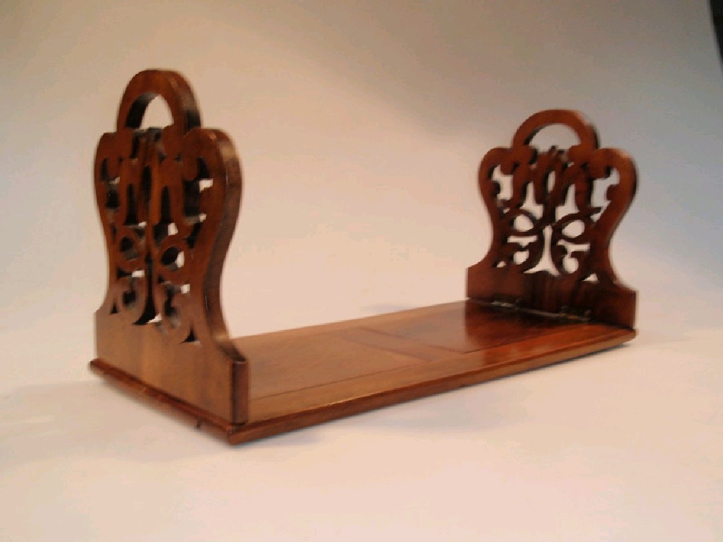 Appraisal: A Victorian walnut book stand with foliate pierced hinged end