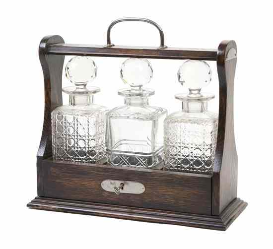 Appraisal: An English Oak Tantalus set with three cut glass decanters