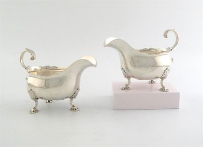 Appraisal: A pair of modern sauceboats with shell feet flying scroll