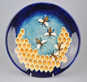 Appraisal: A contemporary Moorcroft plate blue ground decorated with a honeycomb