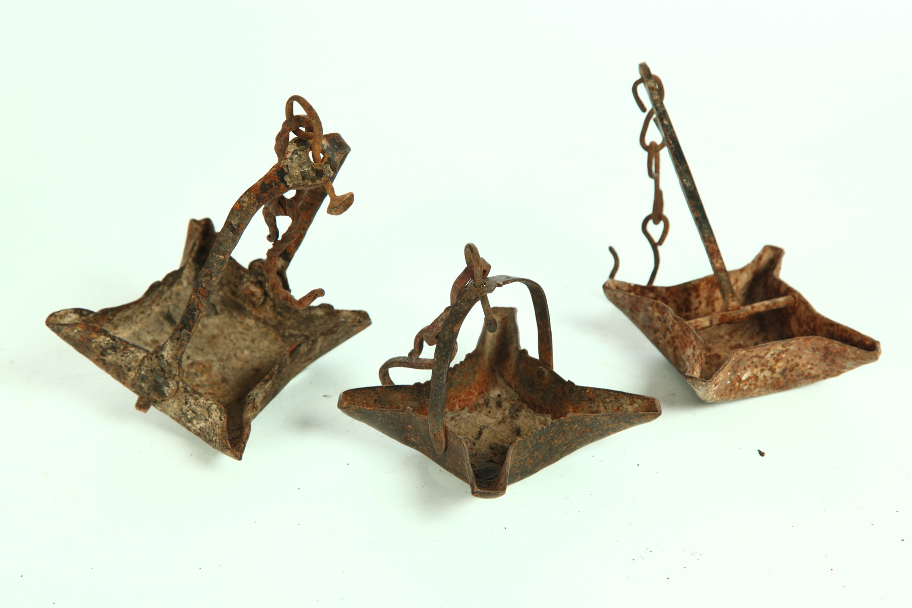 Appraisal: THREE WROUGHT IRON GREASE LAMPS American th century Four spouts