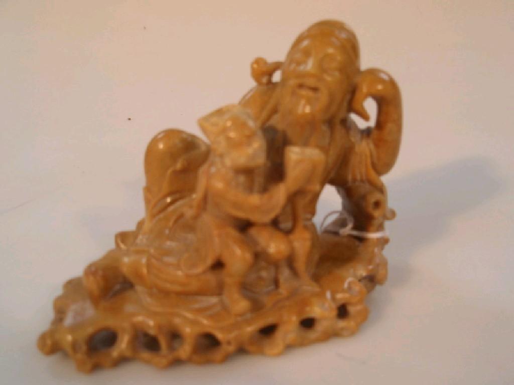 Appraisal: A Chinese soapstone carving of Li Bai with a child