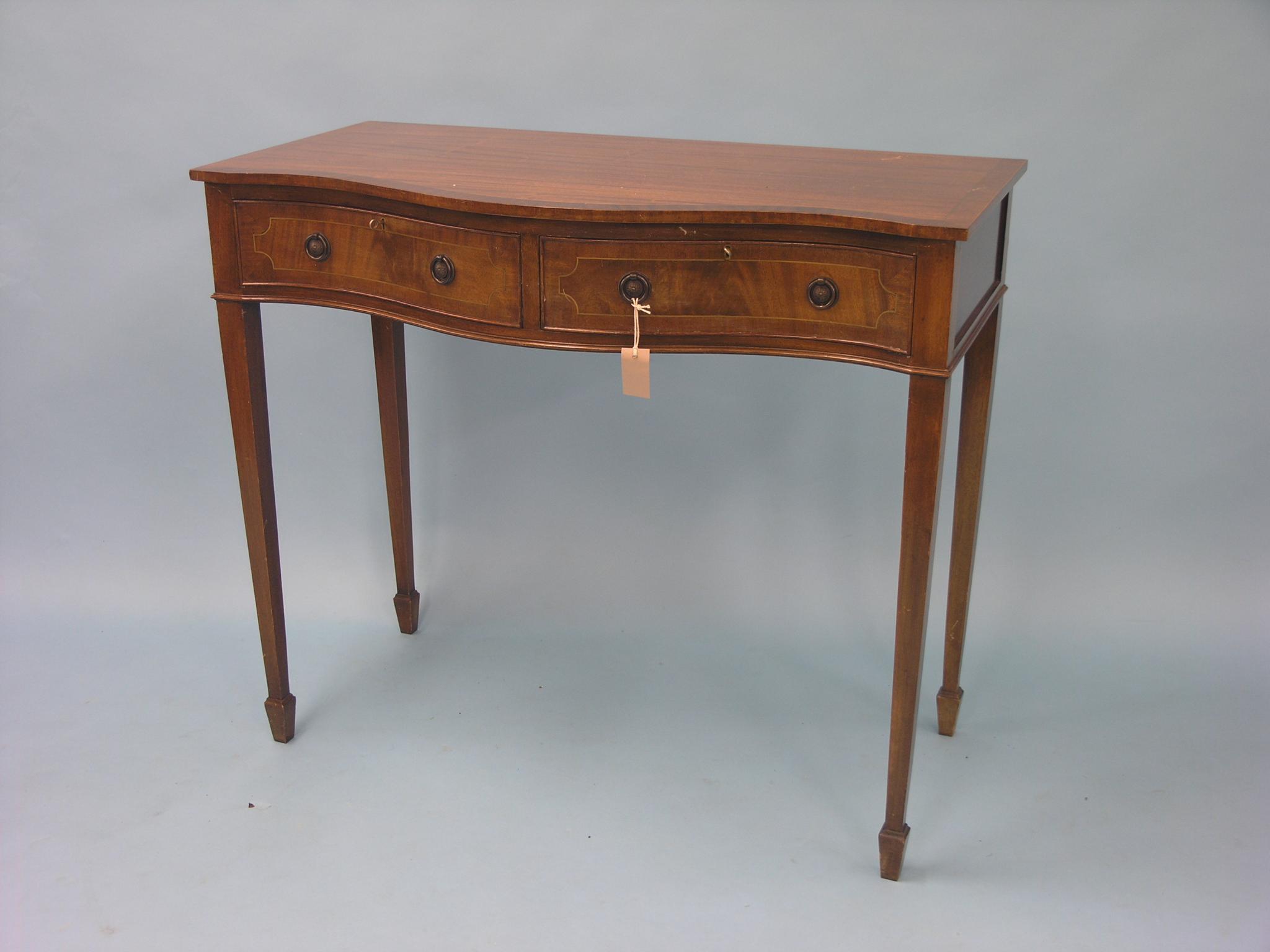 Appraisal: A reproduction mahogany serving table serpentine-fronted with two frieze drawers