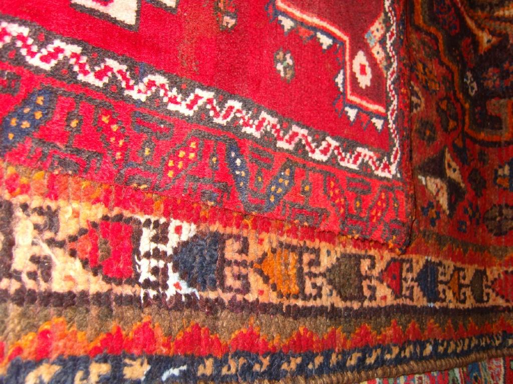 Appraisal: A red ground Eastern wool rug with geometric decoration in