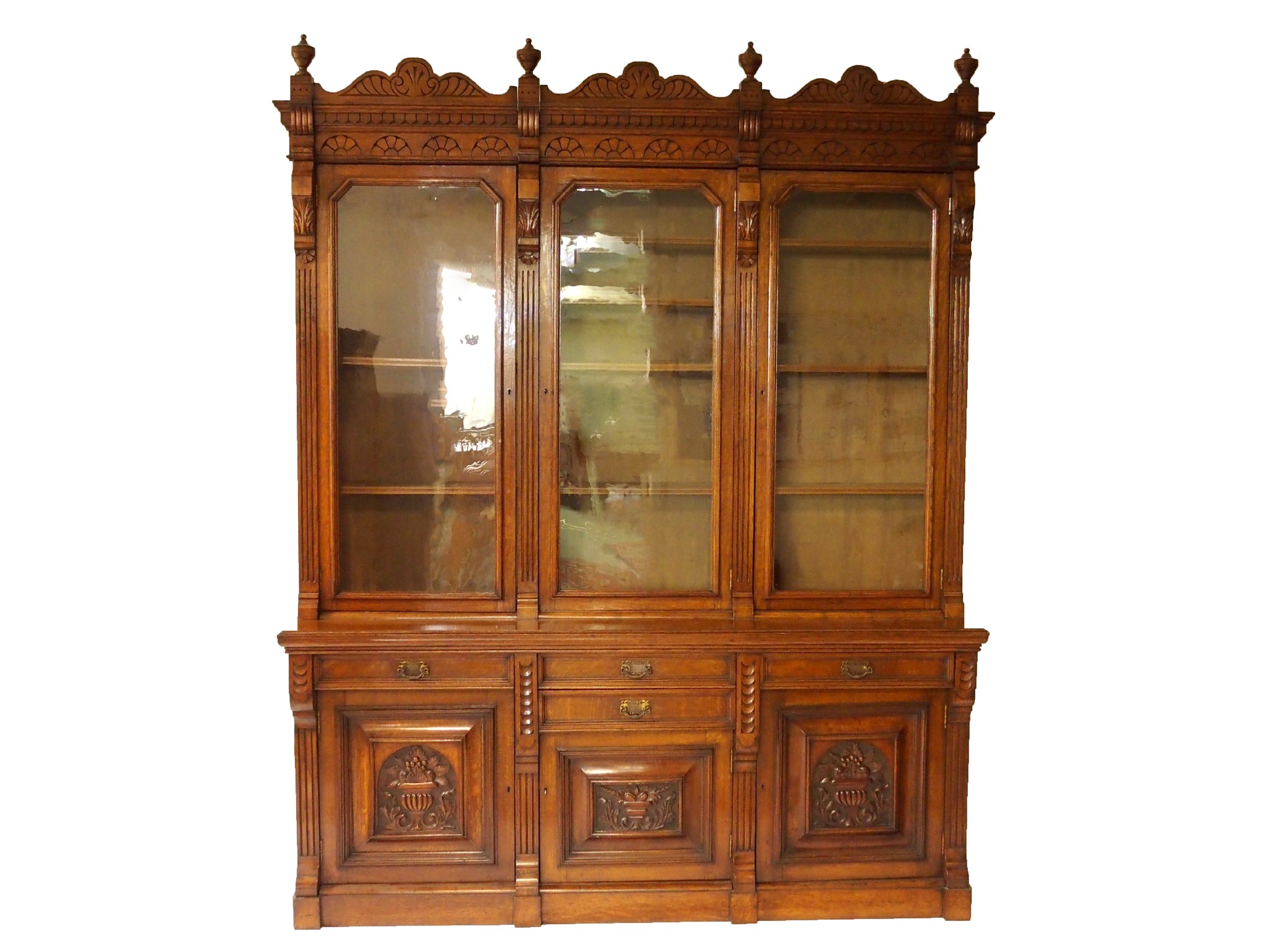 Appraisal: A Victorian oak bookcasewith carved scroll cornice above three glazed