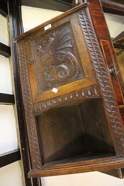 Appraisal: A CARVED OAK SMALL CORNER CUPBOARD with griffen carved panel