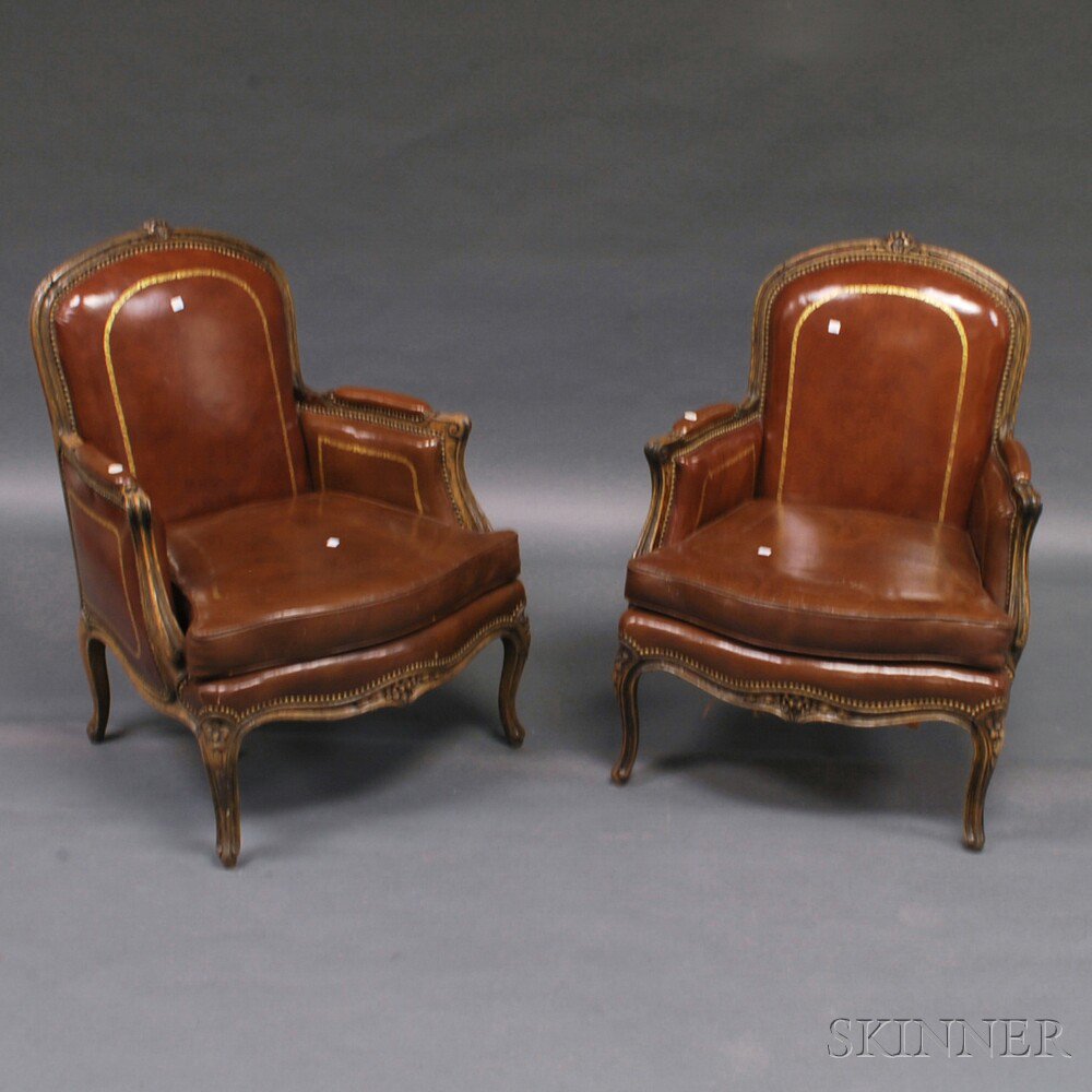 Appraisal: Pair of Louis XV-style Leather-upholstered Oak Bergeres with floral-carved cresting