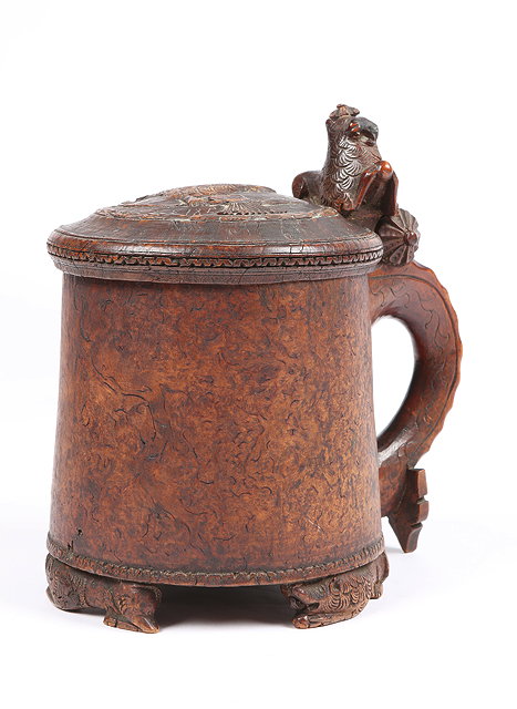 Appraisal: A NORWEGIAN TREEN PEG TANKARD the hinged lid carved with