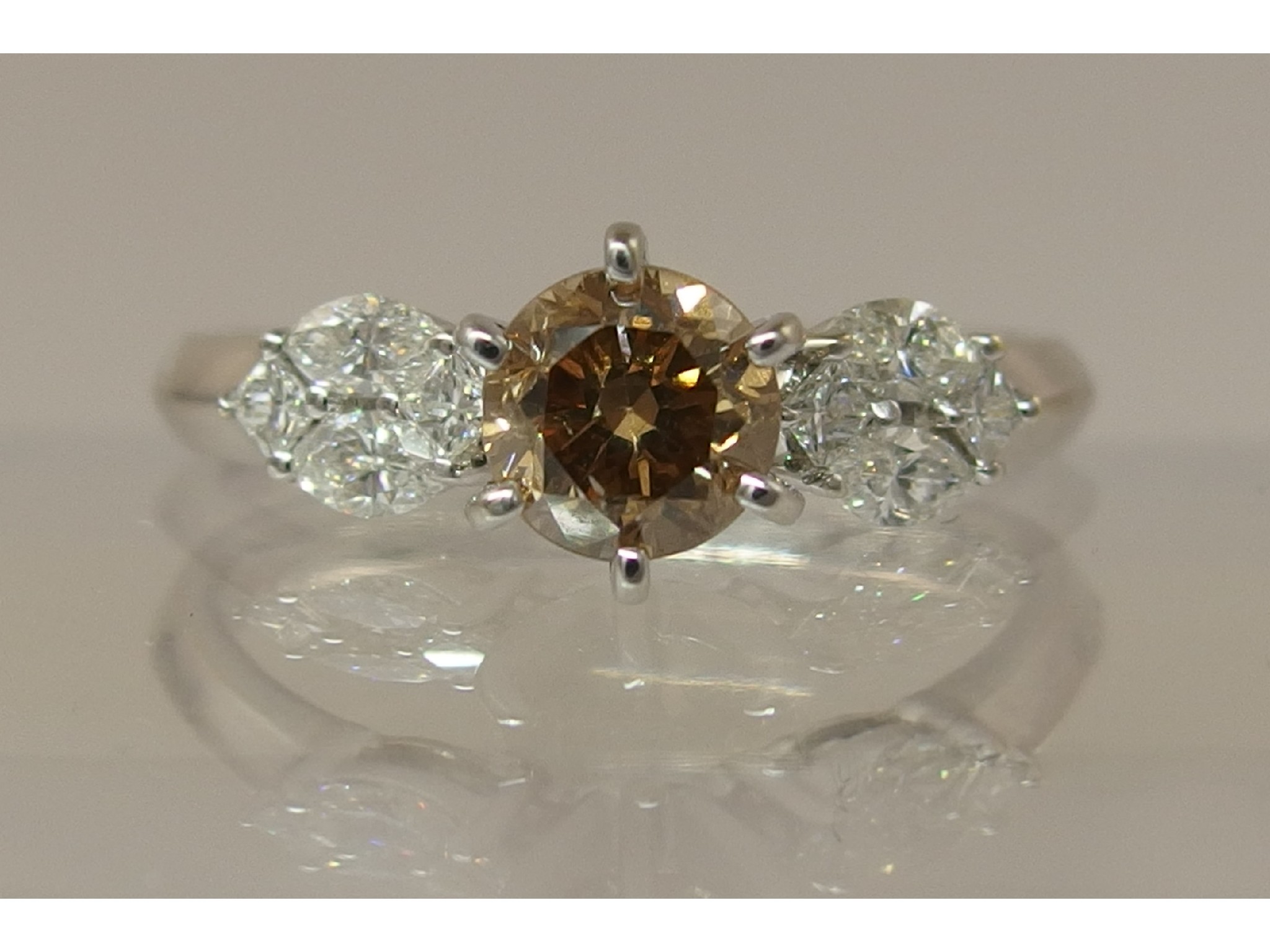 Appraisal: An ct cognac diamond ringwith white diamond clusters to each