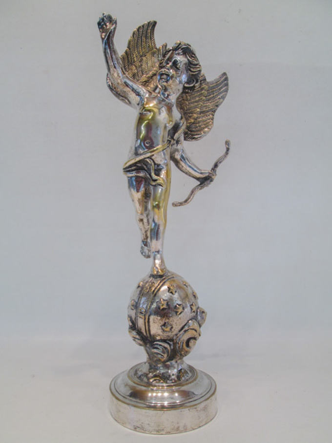 Appraisal: SILVER-PLATED CUPID SCULPTURE depicting a standing Cupid balancing on one