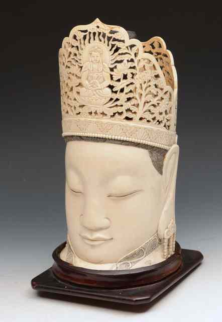 Appraisal: A CHINESE CARVED IVORY HEAD OF GUANYIN having a carved