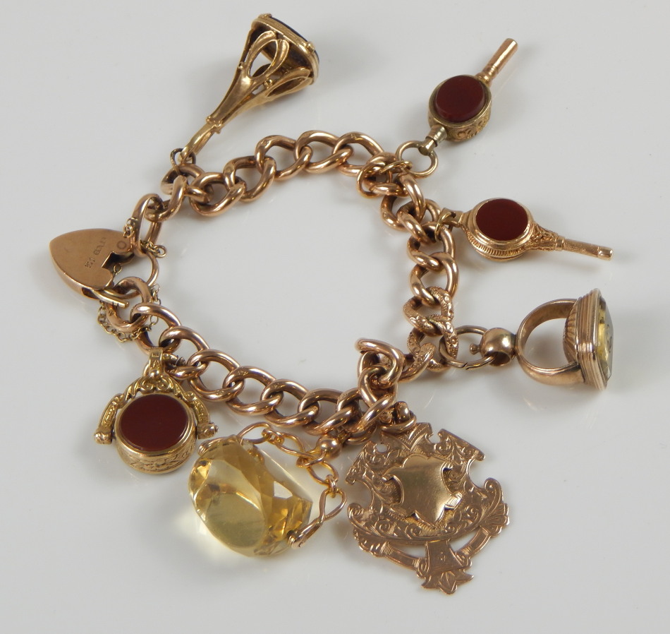 Appraisal: A ct gold charm bracelet with various fobs to include