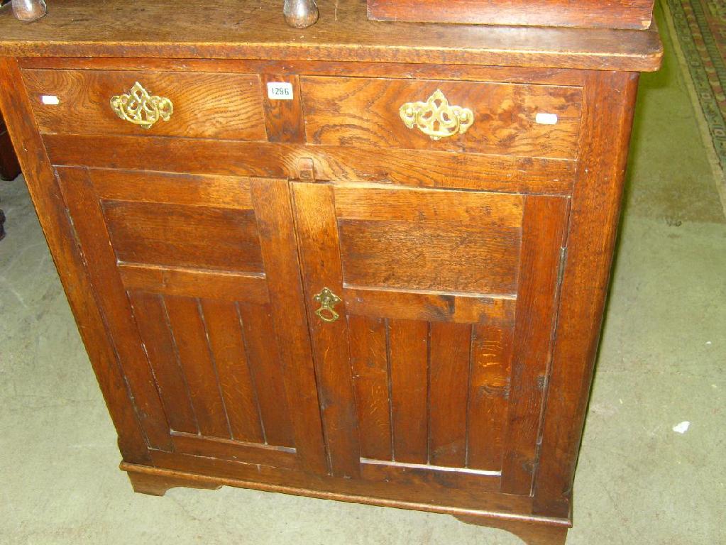 Appraisal: An oak side cupboard fitted with an arrangement of cupboards